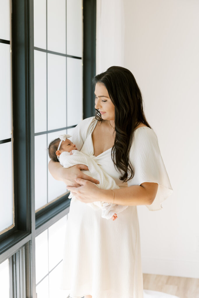 Mother cradling newborn in natural light at The Light Loft studio in Scottsdale