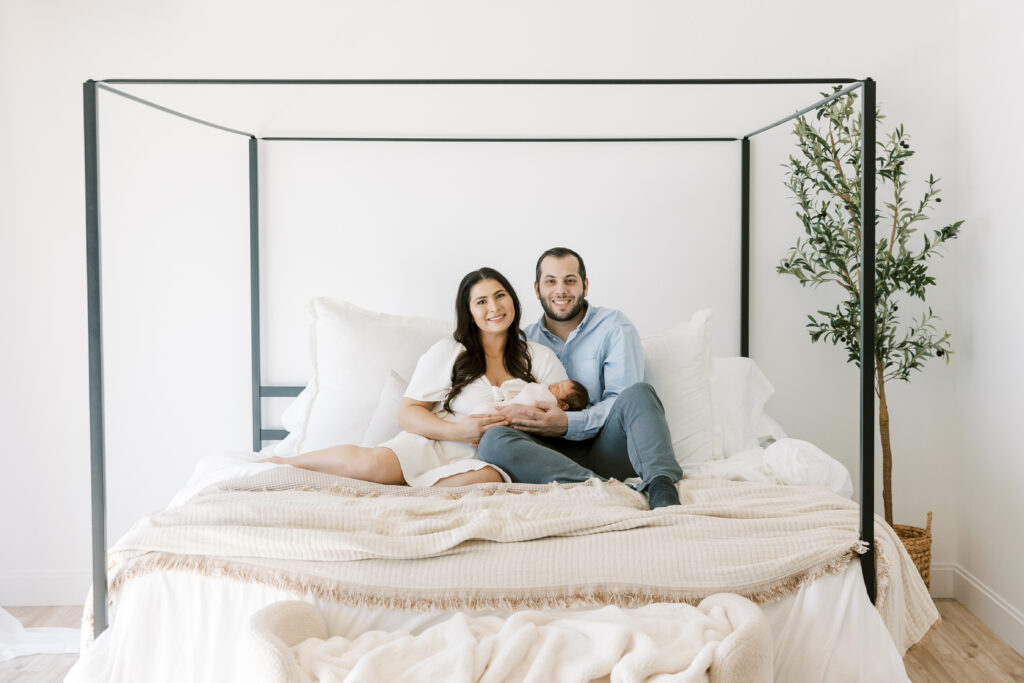 Lifestyle newborn photo scene with baby and parents at the Light Loft Studio