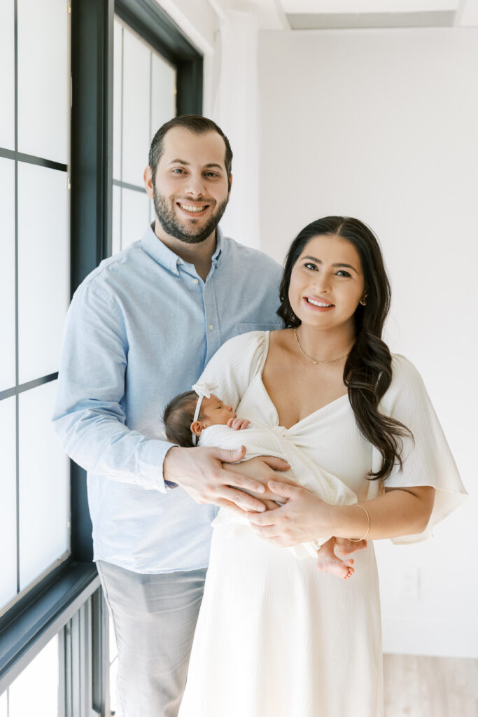 First-time parents holding newborn baby during lifestyle session