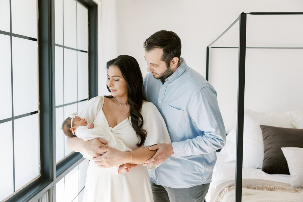 First-time parents holding newborn baby during a newborn lifestyle photography session